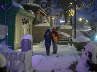 Two people walk down a street in Akureyri, Iceland, on November 19, 2024. (