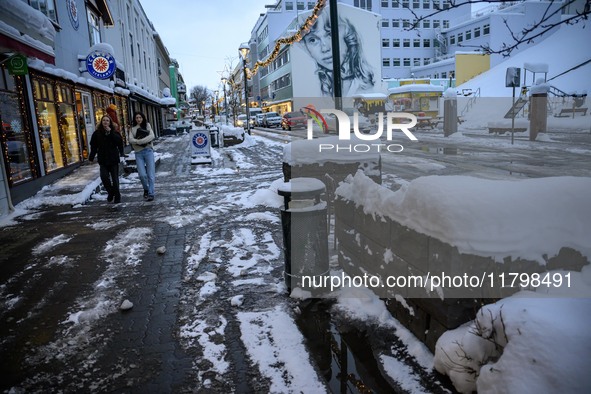 Two people walk down a street in Akureyri, Iceland, on November 19, 2024. 