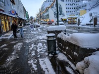 Two people walk down a street in Akureyri, Iceland, on November 19, 2024. (