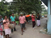 Relatives carry a dead body after performing rituals before cremation in a furnace inside a crematorium at Baruipur Panchayat area in South...