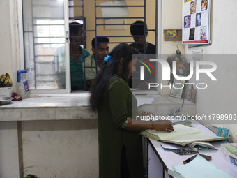 Tumpa Das, age 29, prepares a death certificate while cremating a dead body in a furnace inside a crematorium in the Baruipur Panchayat area...