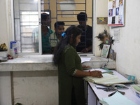 Tumpa Das, age 29, prepares a death certificate while cremating a dead body in a furnace inside a crematorium in the Baruipur Panchayat area...