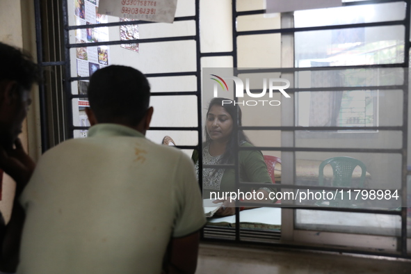 Tumpa Das, age 29, a woman Dom, speaks with relatives before preparing a death certificate during the cremation of a dead body in a furnace...