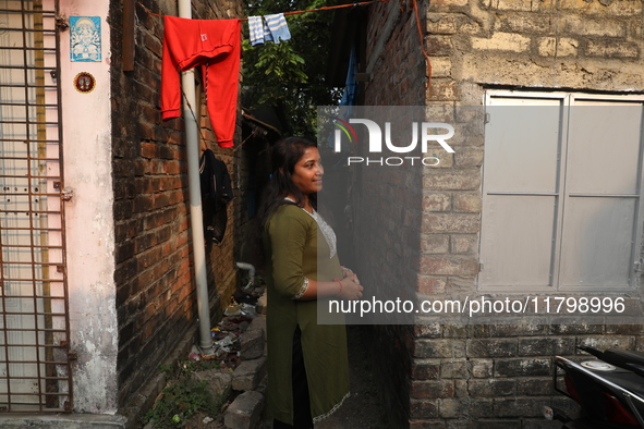 Tumpa Das, age 29, stands in front of her house during the cremation of a dead body in a furnace at a crematorium in the Baruipur Panchayat...