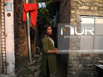 Tumpa Das, age 29, stands in front of her house during the cremation of a dead body in a furnace at a crematorium in the Baruipur Panchayat...