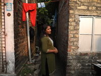 Tumpa Das, age 29, stands in front of her house during the cremation of a dead body in a furnace at a crematorium in the Baruipur Panchayat...