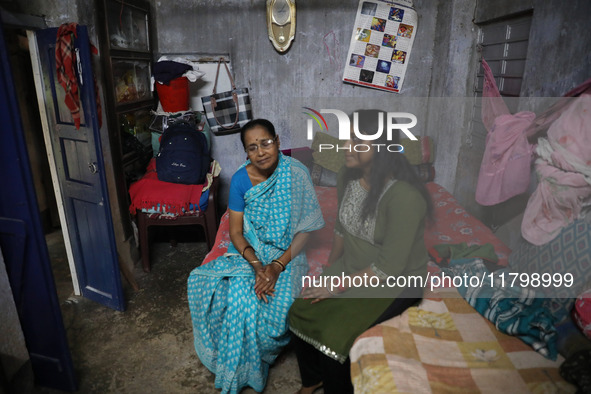 Tumpa Das, age 29, gestures with her mother inside her house during the cremation of a dead body in a furnace at a crematorium in the Baruip...