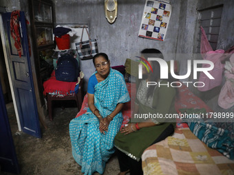 Tumpa Das, age 29, gestures with her mother inside her house during the cremation of a dead body in a furnace at a crematorium in the Baruip...