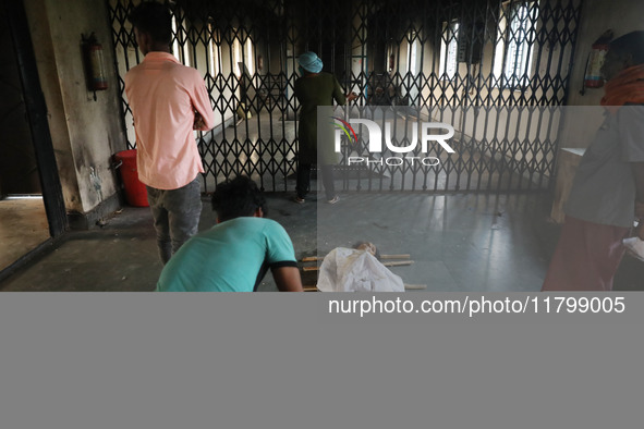 Tumpa Das, age 29, opens the gate for cremating a dead body in a furnace inside a crematorium in the Baruipur Panchayat area in South 24-Par...