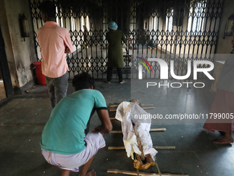 Tumpa Das, age 29, opens the gate for cremating a dead body in a furnace inside a crematorium in the Baruipur Panchayat area in South 24-Par...