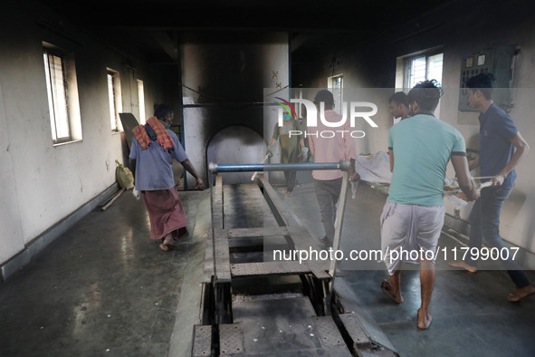 Tumpa Das, age 29, prepares a dead body for cremation in a furnace inside a crematorium in the Baruipur Panchayat area in South 24-Pargana d...