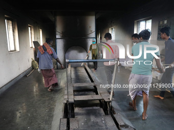 Tumpa Das, age 29, prepares a dead body for cremation in a furnace inside a crematorium in the Baruipur Panchayat area in South 24-Pargana d...