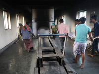 Tumpa Das, age 29, prepares a dead body for cremation in a furnace inside a crematorium in the Baruipur Panchayat area in South 24-Pargana d...