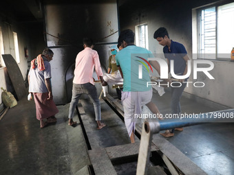 Tumpa Das, age 29, prepares a dead body for cremation in a furnace inside a crematorium in the Baruipur Panchayat area in South 24-Pargana d...