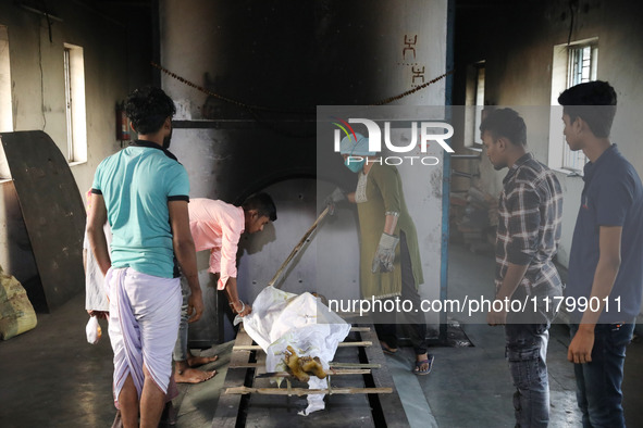 Tumpa Das, age 29, prepares a dead body for cremation in a furnace inside a crematorium in the Baruipur Panchayat area in South 24-Pargana d...