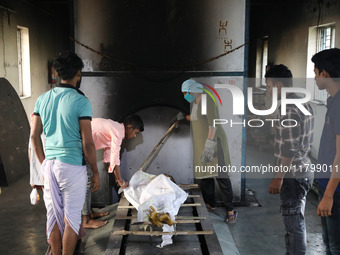 Tumpa Das, age 29, prepares a dead body for cremation in a furnace inside a crematorium in the Baruipur Panchayat area in South 24-Pargana d...