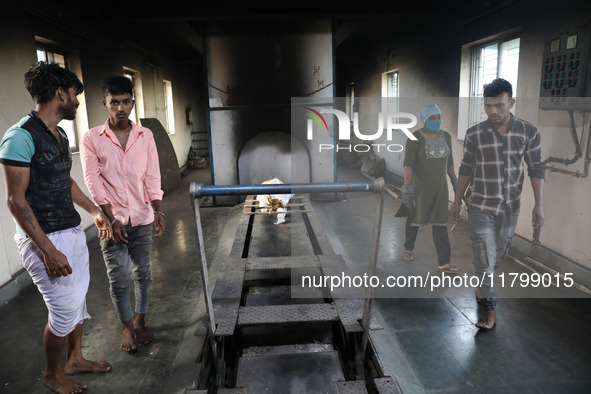 Tumpa Das, age 29, prepares a dead body for cremation in a furnace inside a crematorium in the Baruipur Panchayat area in South 24-Pargana d...