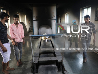 Tumpa Das, age 29, prepares a dead body for cremation in a furnace inside a crematorium in the Baruipur Panchayat area in South 24-Pargana d...