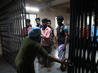 Tumpa Das, age 29, closes the gate before cremating a dead body in a furnace inside a crematorium in the Baruipur Panchayat area in South 24...