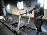 Tumpa Das, age 29, prepares a dead body for cremation in a furnace inside a crematorium in the Baruipur Panchayat area in South 24-Pargana d...