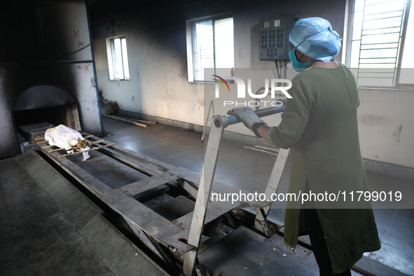 Tumpa Das, age 29, prepares a dead body for cremation in a furnace inside a crematorium in the Baruipur Panchayat area in South 24-Pargana d...