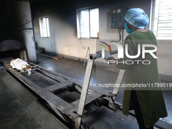 Tumpa Das, age 29, prepares a dead body for cremation in a furnace inside a crematorium in the Baruipur Panchayat area in South 24-Pargana d...