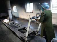 Tumpa Das, age 29, prepares a dead body for cremation in a furnace inside a crematorium in the Baruipur Panchayat area in South 24-Pargana d...