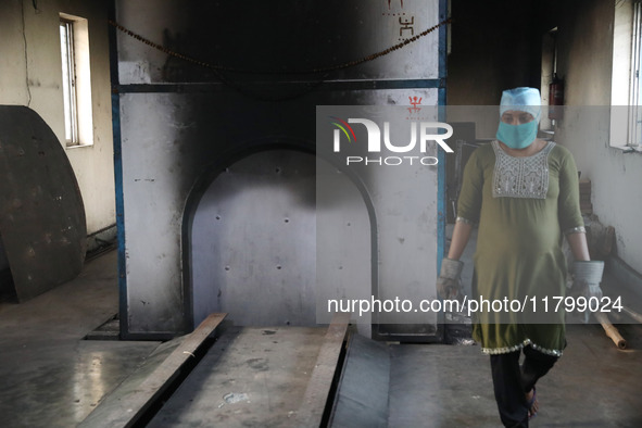 Tumpa Das, age 29, prepares a dead body for cremation in a furnace inside a crematorium in the Baruipur Panchayat area in South 24-Pargana d...