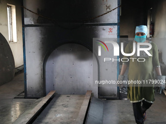 Tumpa Das, age 29, prepares a dead body for cremation in a furnace inside a crematorium in the Baruipur Panchayat area in South 24-Pargana d...