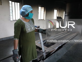 Tumpa Das, age 29, prepares a dead body for cremation in a furnace inside a crematorium in the Baruipur Panchayat area in South 24-Pargana d...