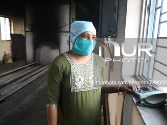 Tumpa Das, age 29, looks outside during the cremation of a dead body in a furnace inside a crematorium at Baruipur Panchayat area in South 2...