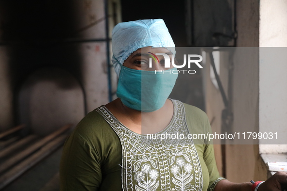 Tumpa Das, age 29, looks outside during the cremation of a dead body in a furnace inside a crematorium at Baruipur Panchayat area in South 2...