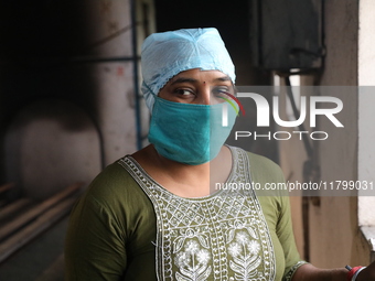 Tumpa Das, age 29, looks outside during the cremation of a dead body in a furnace inside a crematorium at Baruipur Panchayat area in South 2...