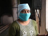 Tumpa Das, age 29, looks outside during the cremation of a dead body in a furnace inside a crematorium at Baruipur Panchayat area in South 2...