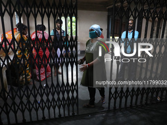 Tumpa Das, age 29, closes the gate during the cremation of a dead body in a furnace inside a crematorium at Baruipur Panchayat area in South...