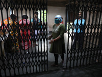 Tumpa Das, age 29, closes the gate during the cremation of a dead body in a furnace inside a crematorium at Baruipur Panchayat area in South...