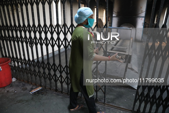 Tumpa Das, age 29, closes the gate during the cremation of a dead body in a furnace inside a crematorium at Baruipur Panchayat area in South...