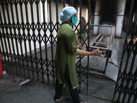 Tumpa Das, age 29, closes the gate during the cremation of a dead body in a furnace inside a crematorium at Baruipur Panchayat area in South...