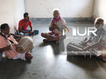 Singers perform a devotional song while Tumpa Das, age 29, a woman Dom, cremates a dead body in a furnace inside a crematorium in the Baruip...