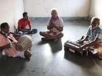 Singers perform a devotional song while Tumpa Das, age 29, a woman Dom, cremates a dead body in a furnace inside a crematorium in the Baruip...