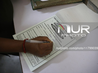 Tumpa Das, age 29, prepares a death certificate while cremating a dead body in a furnace inside a crematorium in the Baruipur Panchayat area...