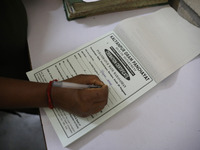 Tumpa Das, age 29, prepares a death certificate while cremating a dead body in a furnace inside a crematorium in the Baruipur Panchayat area...