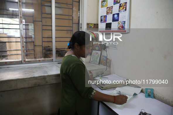 Tumpa Das, age 29, prepares a death certificate while cremating a dead body in a furnace inside a crematorium in the Baruipur Panchayat area...