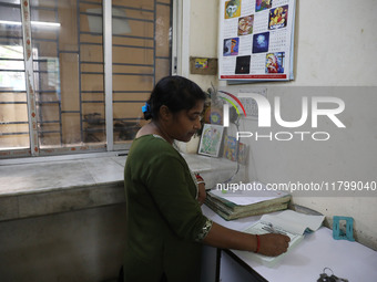 Tumpa Das, age 29, prepares a death certificate while cremating a dead body in a furnace inside a crematorium in the Baruipur Panchayat area...