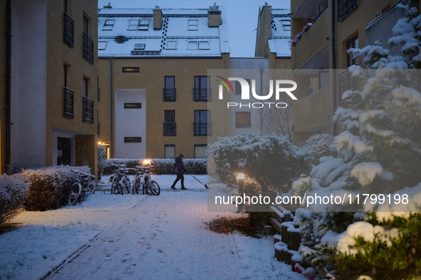 A man shovels snow in a residential neighbourhood in Warsaw, Poland on 22 November, 2024. It is the first time in recent years significant s...