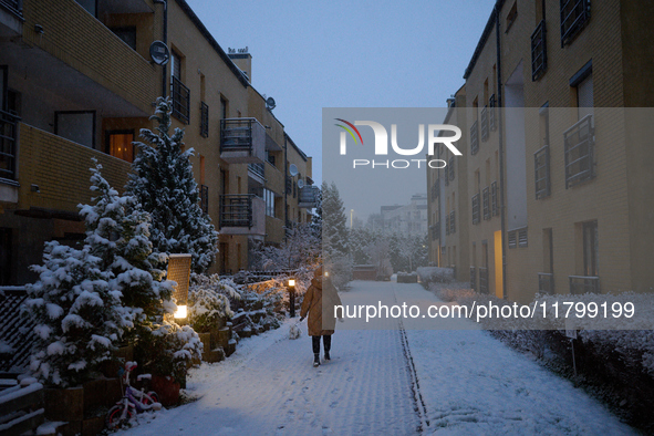 A woman walks a dog in the early morning in Warsaw, Poland on 22 November, 2024. It is the first time in recent years significant snow has f...