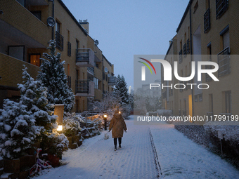 A woman walks a dog in the early morning in Warsaw, Poland on 22 November, 2024. It is the first time in recent years significant snow has f...