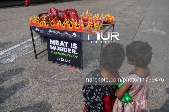 Activists of People for the Ethical Treatment of Animals (PETA) are seen drenched in fake blood and sleep on a figurative oven as they stage...