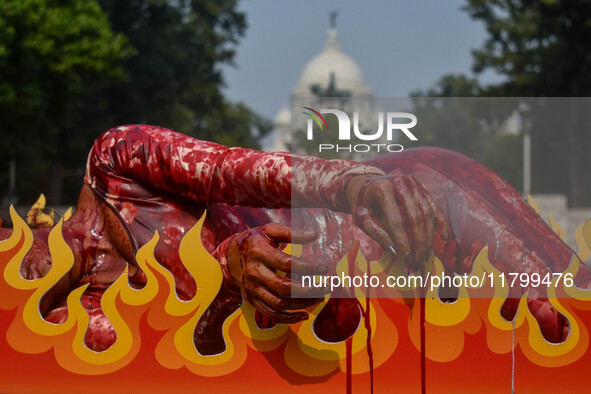 Activists of People for the Ethical Treatment of Animals (PETA) are seen drenched in fake blood and sleep on a figurative oven as they stage...