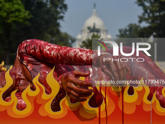 Activists of People for the Ethical Treatment of Animals (PETA) are seen drenched in fake blood and sleep on a figurative oven as they stage...